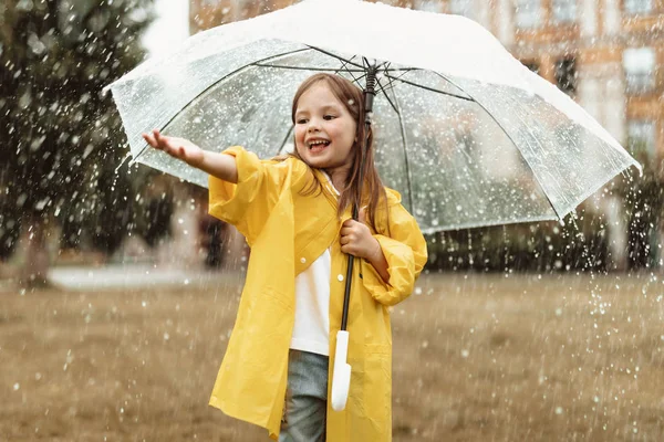 Positives Kind fängt Regentropfen draußen ein — Stockfoto