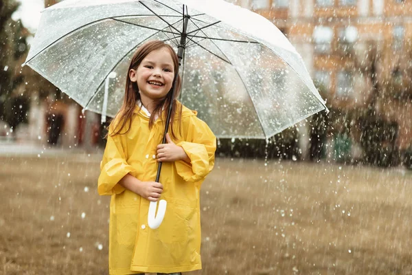 Fröhliches Mädchen spielt draußen im Regen — Stockfoto