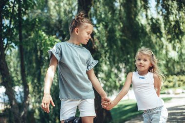 Küçük çocuklar birlikte parkta yürüyüş