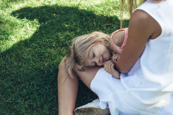 Felice bambino a riposo su mamma gamba con gioia — Foto Stock