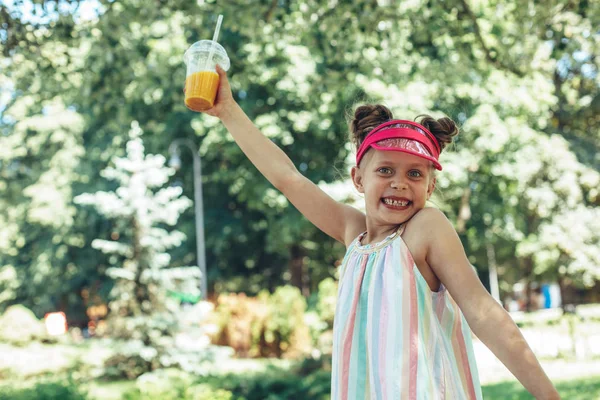 Garota excitada andando no parque com bebida — Fotografia de Stock