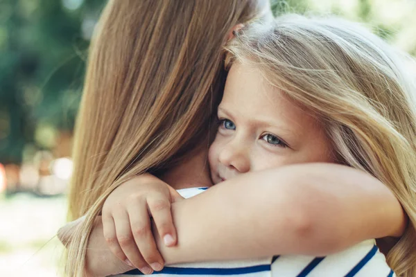 Happy kid embracing mother in nature — Stock Photo, Image