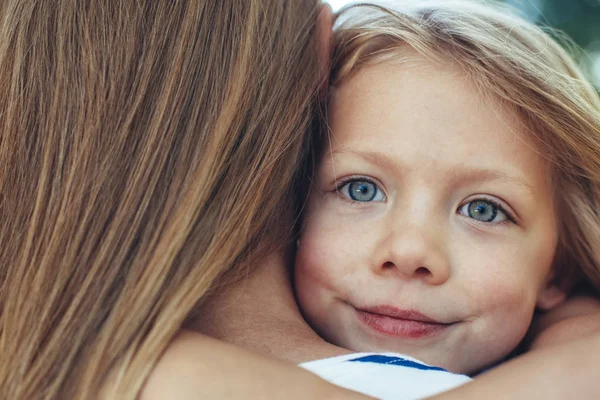 Sonriente niño sosteniendo la madre firmemente — Foto de Stock