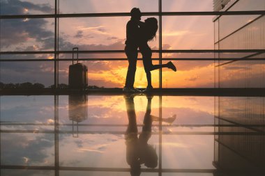 Tam uzunlukta yan görünümü mutlu kız sarılma neşeli erkek. Günbatımı sırasında Bagaj Havaalanı yakınındaki duruyorlar