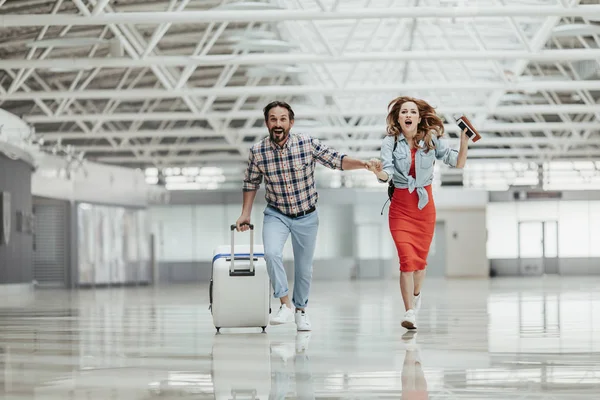 Otimista masculino e menina correndo com bagagem — Fotografia de Stock