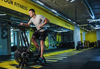 Mutlu adam üzerinde orbitrek spor salonunda koşu