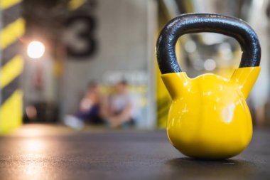 Ağır sarı kettlebell sporcular spor salonunda bekliyor