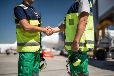 Airport workers shaking hands clipart