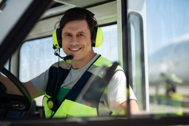 Havaalanı servis personeli direksiyonuna oturan adamdan gülümseyen