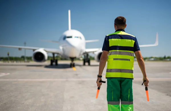 Luchtvaart marshaller kijken vliegtuig op baan — Stockfoto