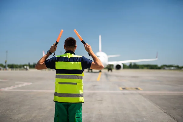 Pracownik lotniska, ogląda samolotu pasażerskiego i sygnalizacji — Zdjęcie stockowe
