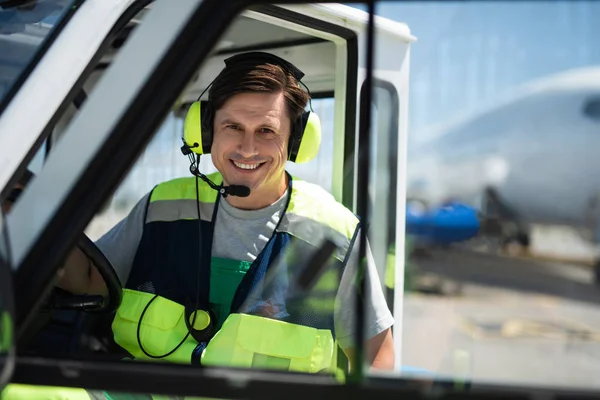 Alegre trabajador del aeropuerto posando dentro del coche — Foto de Stock