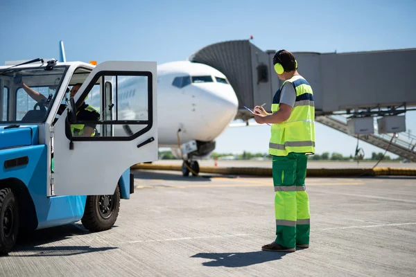 Manliga arbetare styra flygplan medan kollega som sitter i bilen — Stockfoto