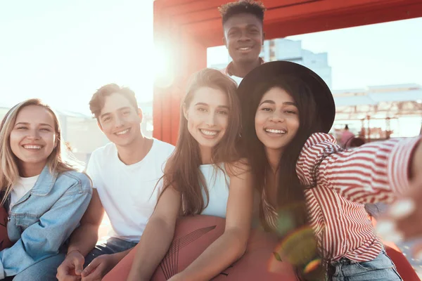 Hombres y mujeres positivos relajándose al aire libre — Foto de Stock