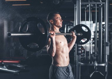 Vücut geliştirmeci ile ağır ekipman spor salonunda egzersiz