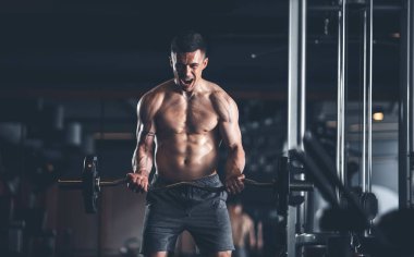 Kızgın adam ağırlık ile egzersiz sırasında bağırıyor