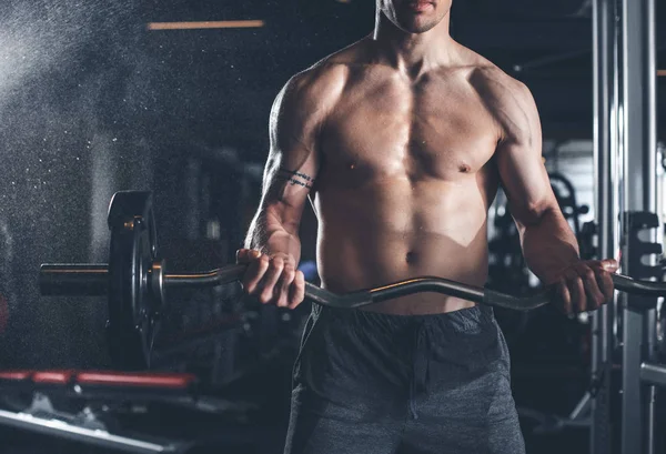 Fisiculturista está segurando barbell no ginásio — Fotografia de Stock