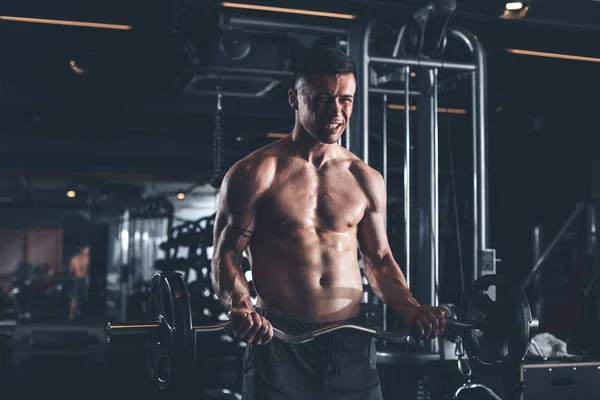 Gespannen man is het gebruik van zware barbell in sportschool — Stockfoto