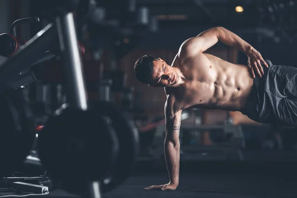 El hombre decidido está balanceándose en un brazo en el gimnasio — Foto de Stock