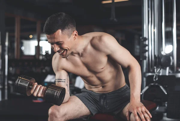 Homem alegre está desfrutando de treino na parte superior do corpo dentro de casa — Fotografia de Stock