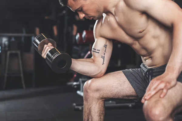 Zgrywanie Wytatuowany mężczyzna pracuje na biceps ulgi — Zdjęcie stockowe