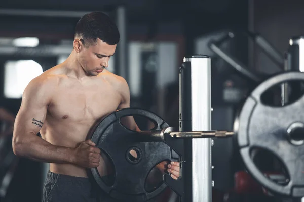 Serious athlete is exploiting weights in sport club — Stock Photo, Image