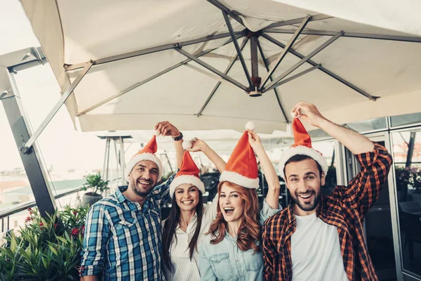 Veselý přátel dojemné střapce na santa klobouky — Stock fotografie