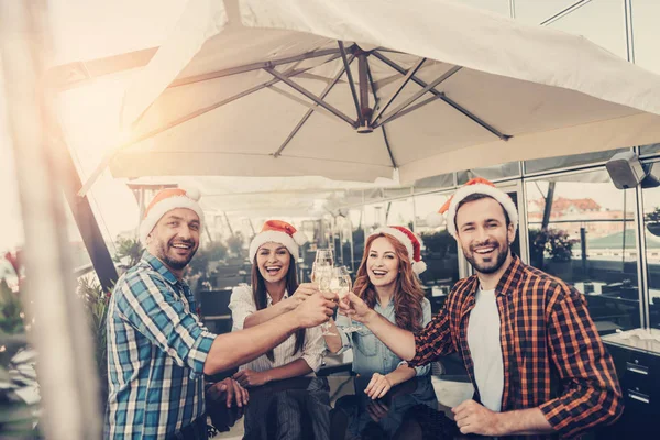 Cheerful company celebrating new year at cozy cafe — Stock Photo, Image