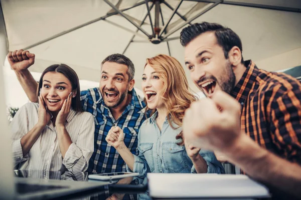 Gruppen av glada människor i café förvånad av bra online-nyheter — Stockfoto