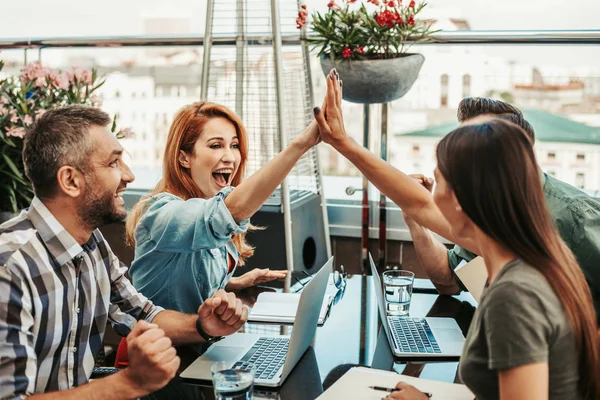 Glada unga damer ger hög fem med manliga kollegor — Stockfoto