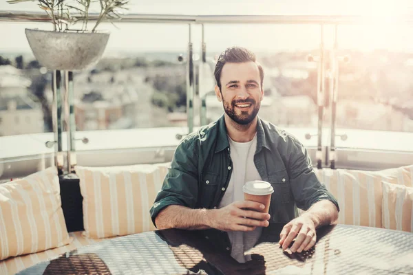 커피 한잔 들고 야외 카페에서 쾌활 한 수염된 남자 — 스톡 사진