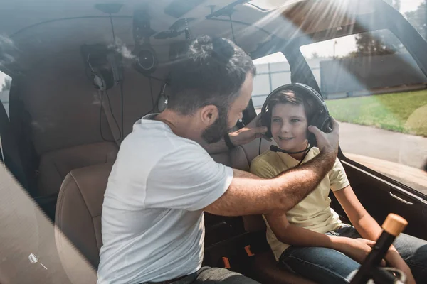 Hombre y niño satisfechos sentados en helicóptero — Foto de Stock