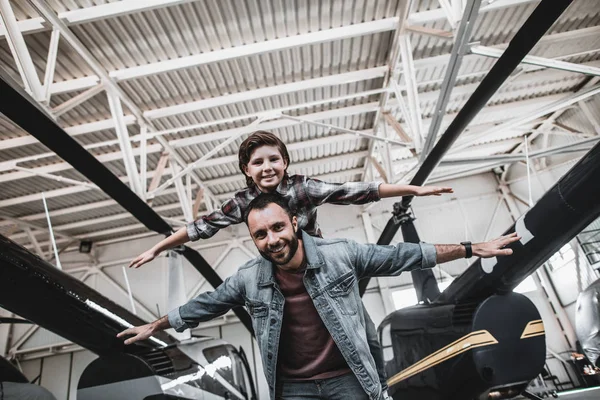 Positiv man underhållande med pojke nära helikoptrar — Stockfoto