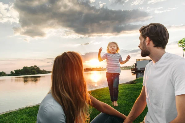 Criança sorridente movendo-se para parentes felizes ao ar livre — Fotografia de Stock