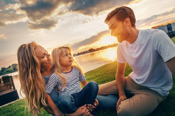 Strahlendes Paar mit frohem Kind entspannt draußen — Stockfoto