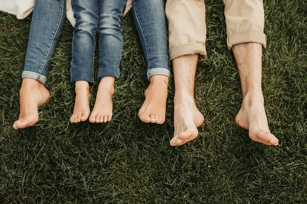 Family feet locating on cozy green ground — Stock Photo, Image