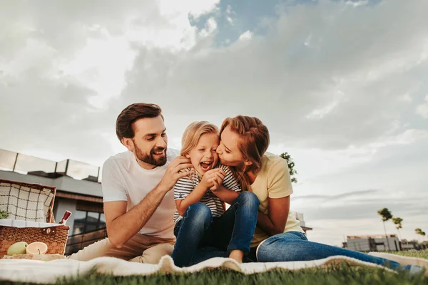 Blij stel met blij kind tijdens picknick — Stockfoto