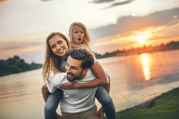 Счастливые родители и девочка, развлекающаяся на природе — стоковое фото