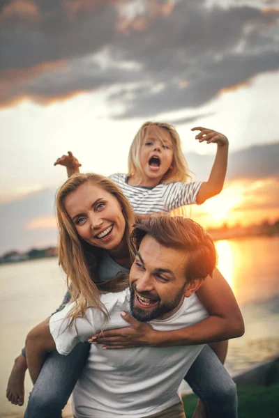 Позитивні батьки розважаються з щасливою дочкою — стокове фото