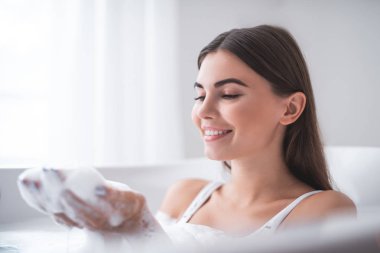 Eğlenceyle ilgili kapalı suda köpük görürken memnun Bayan gesticulating eller portresi. Geri kalan kavramı sırasında mutlu erkek