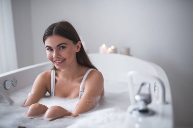 Memnun kız banyoda köpüklü içinde