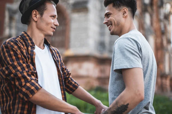 Optimistischer Mann hält Arme eines zufriedenen Freundes — Stockfoto