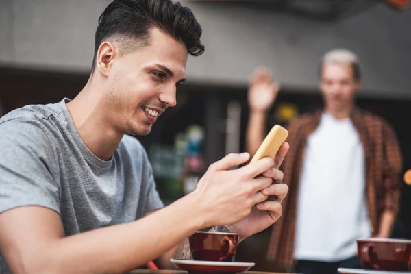 Nöjd man använder digital enhet på skrivbord — Stockfoto