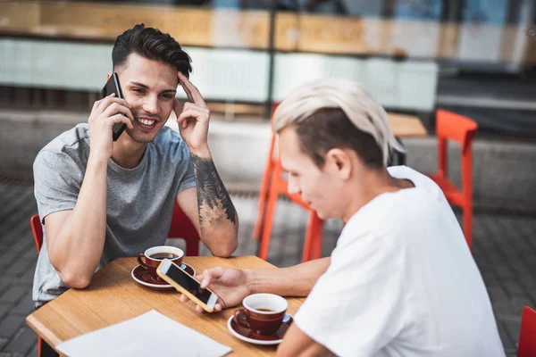 Glada män med digital enhet i café — Stockfoto