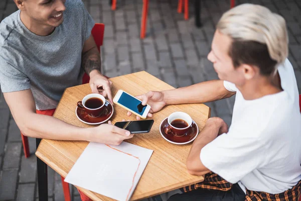 Optimistiska män talar och använder digital enhet — Stockfoto