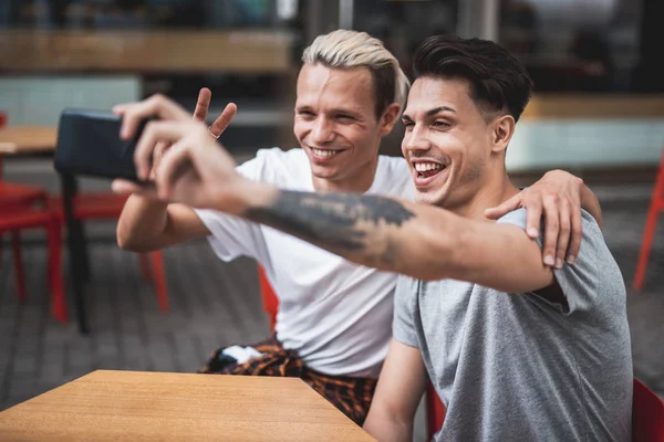 Glada tarmar gör foto på mobil utomhus — Stockfoto