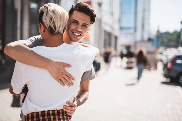 Tipo optimista abrazando al camarada en la calle —  Fotos de Stock