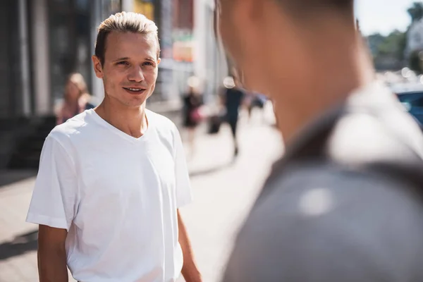 Positive männliche Kommunikation mit Kamerad in der Stadt — Stockfoto