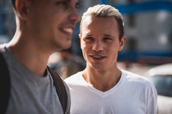 Optimistiska män kommunicerar under promenad i staden — Stockfoto