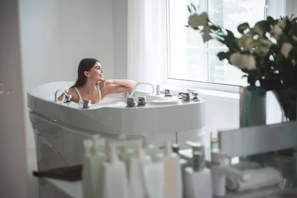 Ragazza positiva che riposa in acqua in appartamento — Foto Stock